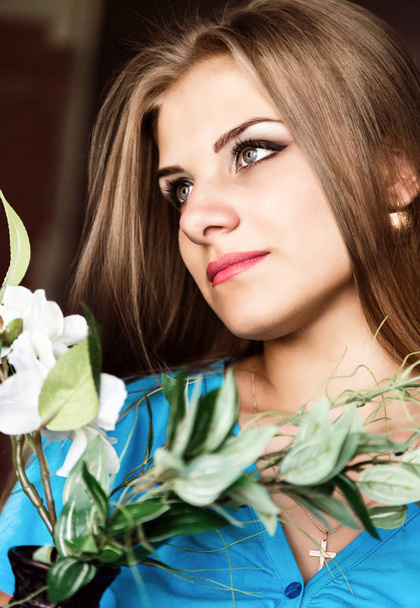close up young blonde beauty woman with flowers on a dark background. professional makeup - Foto, afbeelding
