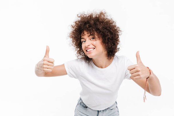 Happy smiling girl with curly hair showing two thumbs up - Photo, Image