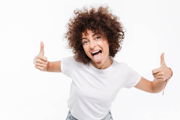 Happy smiling girl with curly hair showing two thumbs up - Φωτογραφία, εικόνα