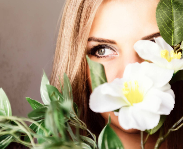 close up young blonde beauty woman with flowers on a dark background. professional makeup - Fotoğraf, Görsel