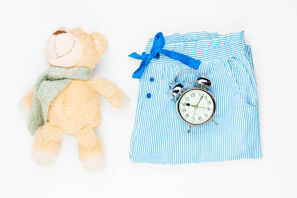 плюшева іграшка, піжама штани і будильник вид зверху на w
 - Фото, зображення