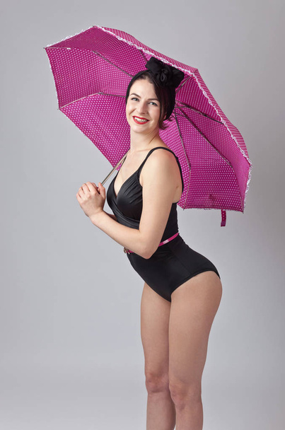 Kobieta w czarnym bikini z parasolem . - Zdjęcie, obraz