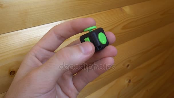 male hand uses a black and green fidget cube-antistress - Metraje, vídeo