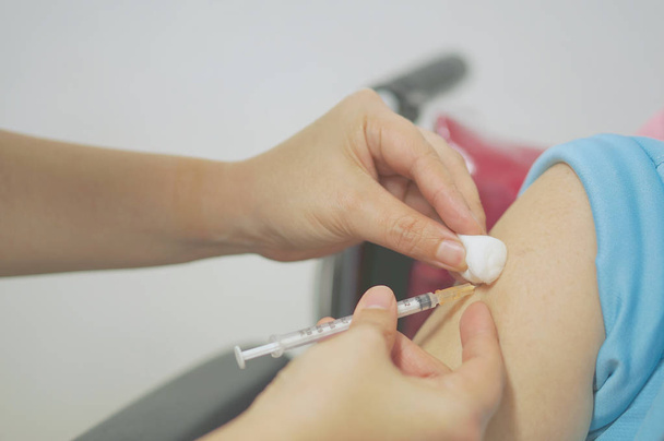 Une infirmière tenant une seringue hypodermique et une boule de coton a injecté le vaccin
 - Photo, image