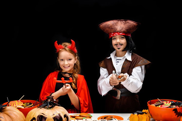 children in halloween costumes of devil and pirate  - Foto, Imagen