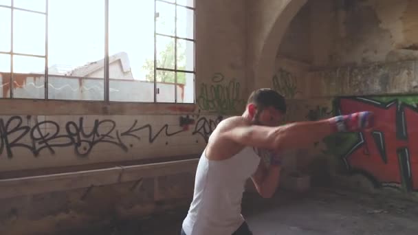 古い断念された建物にシャドウ ボクシング運動を行う男性のボクサー - 映像、動画