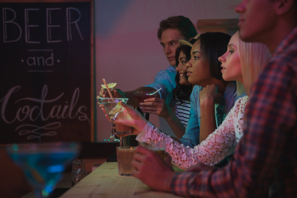 multi-etnisch vrienden drinken van cocktails in bar - Foto, afbeelding
