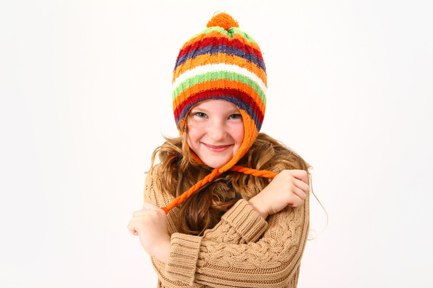 Cheerful little girl in colorful sweater and hat isolated on whi - Foto, Imagem