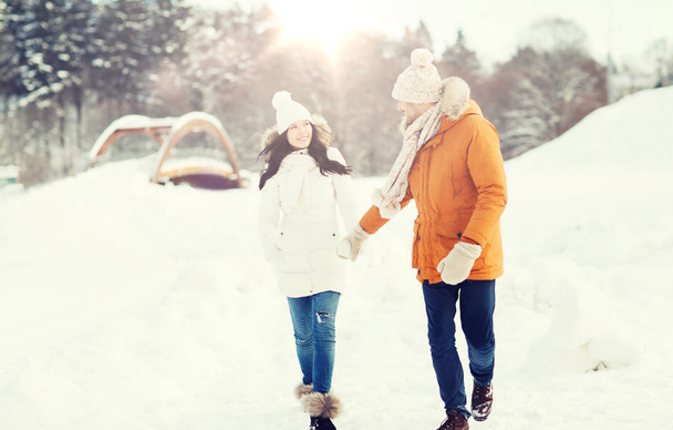 happy couple walking over winter background - Foto, imagen