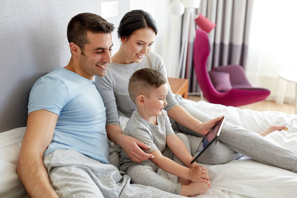 happy family with tablet pc in bed at home - Valokuva, kuva