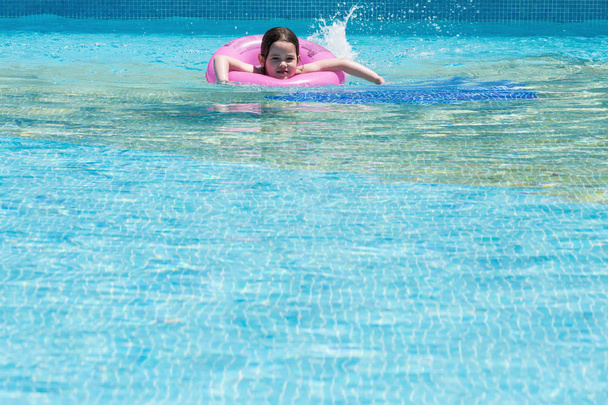 Little girl swimming in a pool - 写真・画像