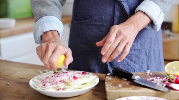 Nainen puristaa sitruunaa yli leikattu retiisit ja fenkoli
 - Materiaali, video