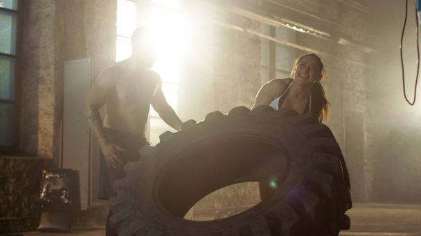 Fit Athletic Woman Lifts Tire Under Supervision of Her Partner/  - Foto, Imagen