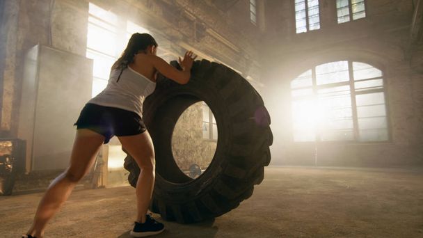 Fit Athletic Woman Lifts Tire as Part of Her Cross Fitness/ Body - Photo, Image