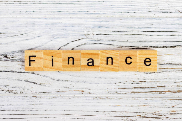 Οικονομικών λέξη γραμμένη σε ξύλο μπλοκ σχετικά με τον πίνακα - Φωτογραφία, εικόνα