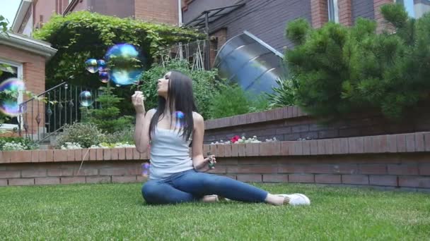 Lány felfújódik a kertben szappanbuborékok - Felvétel, videó