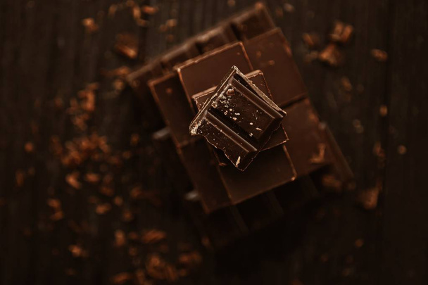 Delicious black and milk chocolate on a brown background  - Photo, Image