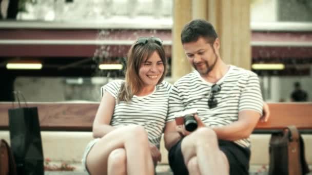 Giovane coppia felice guardando le foto nella fotocamera compatta durante la loro vacanza
 - Filmati, video