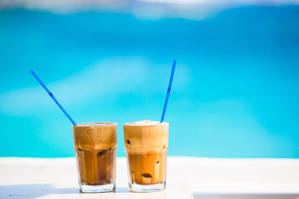 Frappe, mrożona kawa na plaży. Latem mrożona kawa frappuccino, frappe lub latte w wysokim szklanym tle morze w barze na plaży - Zdjęcie, obraz