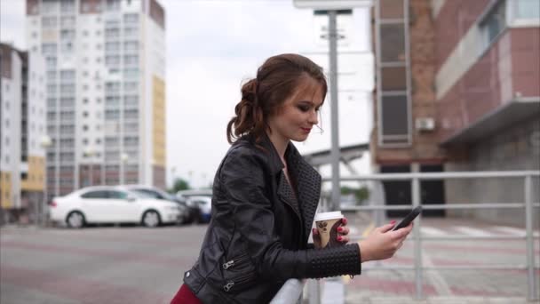 Bella bruna con cellulare e caffè in strada
 - Filmati, video