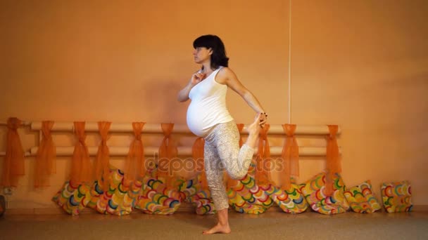 40 settimane di gravidanza di mezza età donna caucasica che fa esercizi di yoga vincolato Signore della Danza Pose
. - Filmati, video