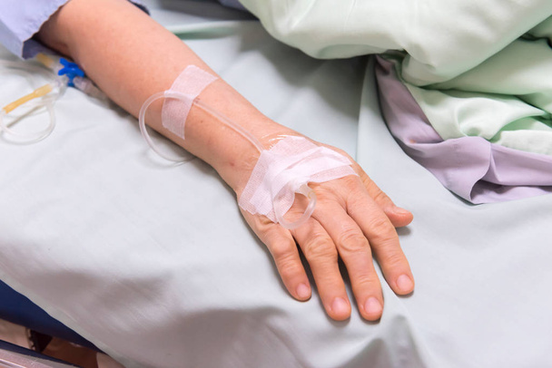Κλείστε το χέρι του ασθενούς στο νοσοκομείο ward, έννοια ασθενή υγειονομική περίθαλψη. - Φωτογραφία, εικόνα