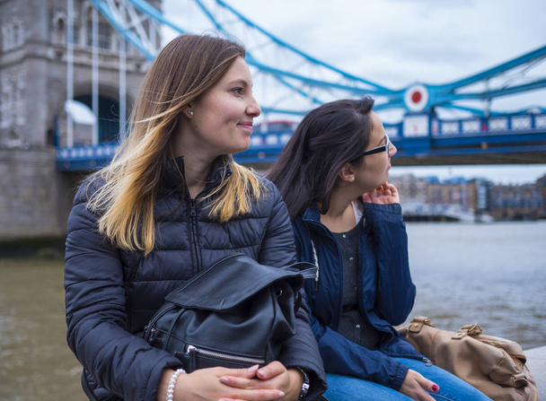 Two girls on a city trip to London - relax at the Tower Bridge - Фото, изображение