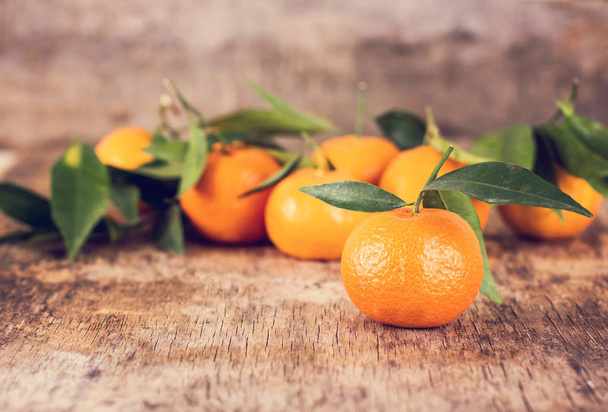 Mandarin. Many mandarins lie on a wooden table. - Фото, изображение
