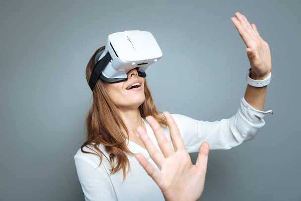 Mooie positieve vrouw wordt opgewekt over de virtuele realiteit - Foto, afbeelding