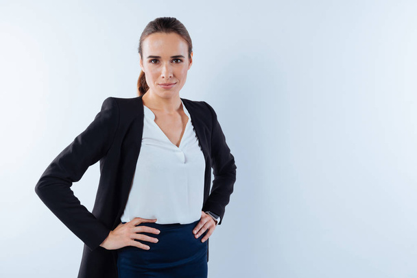 Serious nice businesswoman putting her hands on hips - Photo, image