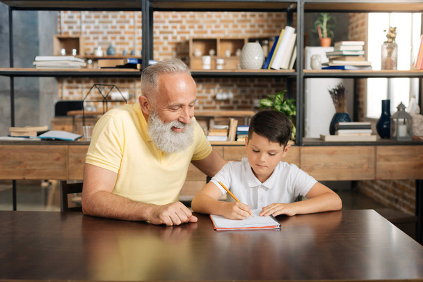 Caring grandfather helping his grandson with home assignment - Φωτογραφία, εικόνα