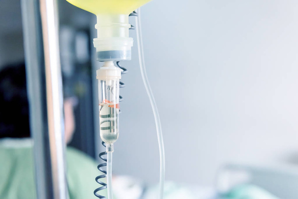 Detailní záběr odkapávací solný roztok pro pacienta a infuzní pumpy v nemocnici, léčbu nemoci doktor koncepce. - Fotografie, Obrázek