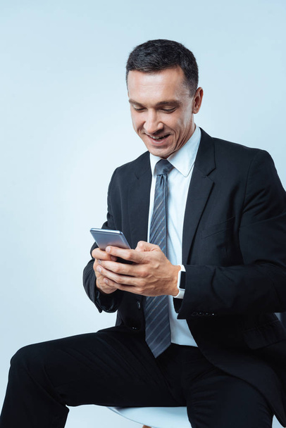 Cheerful delighted man texting a message - Фото, зображення