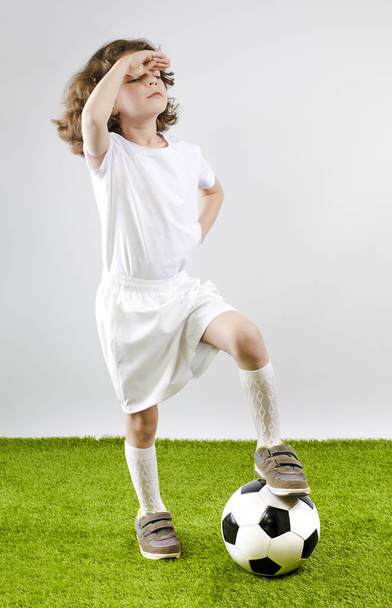 Boy with soccer ball on a gray background. Back view - Photo, Image