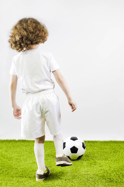 Boy with soccer ball on a gray background. Back view - Fotoğraf, Görsel