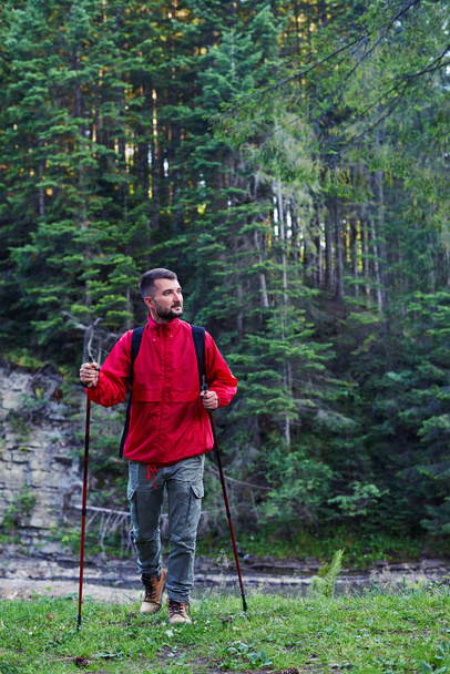 Ο άνθρωπος σε πεζοπορία στολή με πόλους στα βουνά  - Φωτογραφία, εικόνα