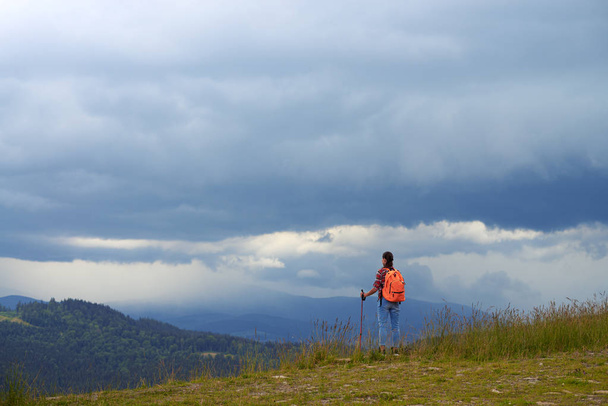 Gros plan de femme avec des bâtons de randonnée sur le sommet de la montagne
 - Photo, image