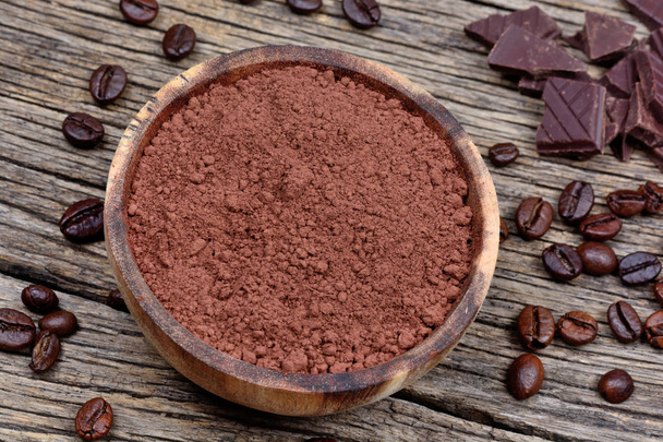 Bowl with cacao powder and coffee beans on rustic table - Photo, Image
