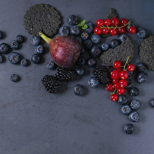 Variety of berries and figs with black crackers - Fotografie, Obrázek