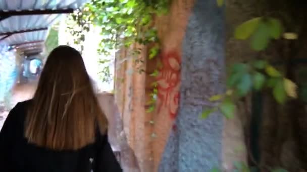 Młoda Blondynka z długimi włosami idzie na opustoszałej ulicy - Materiał filmowy, wideo