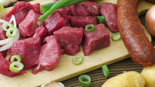 Suroviny pro guláš, guláš či polévku. Čerstvé syrové sekané hovězí maso na dřevěném prkénku s kořením a zeleninou. - Záběry, video
