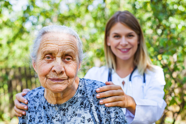 Vanhempi nainen lääkärin kanssa puistossa
 - Valokuva, kuva