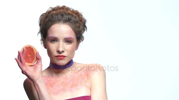 junge Frau hält Grapefruitscheibe in der Hand. - Filmmaterial, Video