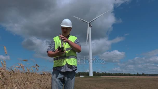 Elektricien op de walkie-talkie in de buurt van de windturbines - Video