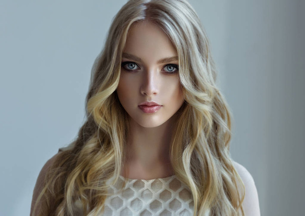 Blonde   girl with long  , curly hair  - Foto, afbeelding