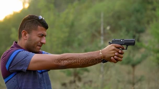 Genç Arap adam bir silahtan ateş ediyor yakın çekim - Video, Çekim