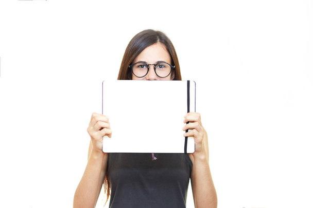 Portrait young woman in glasses isolated over white background holds a notebook - Fotoğraf, Görsel