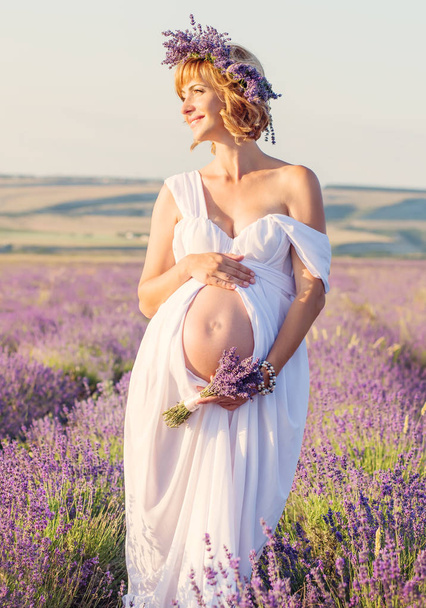 Όμορφη έγκυος γυναίκα σε ένα λευκό φόρεμα  - Φωτογραφία, εικόνα