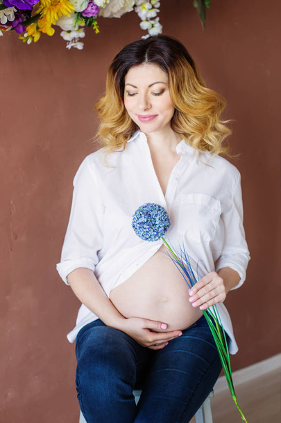 Primo piano della donna incinta, In camicia bianca e jeans
 - Foto, immagini