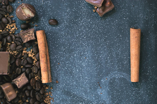Sweet still life. Coffee beans, chocolate bars and cinnamon sticks. - Фото, зображення